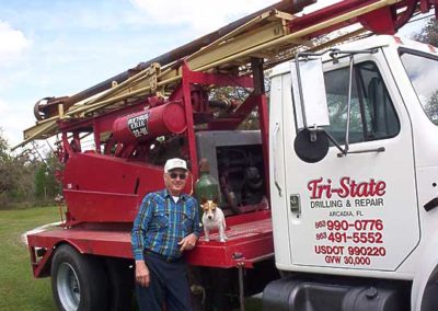 Tri-State Drilling & Repair, Inc. employee Larry with his dog stand beside a Tri-State Drilling truck